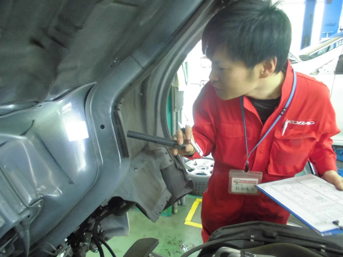 車両の下回りを点検する整備スタッフ